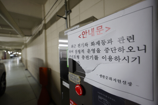 지난 12일 서울 시내 한 아파트 지하 주차장에 설치된 고정형 전기차 충전기에 운영 중단 안내문이 붙어 있다. 연합뉴스.